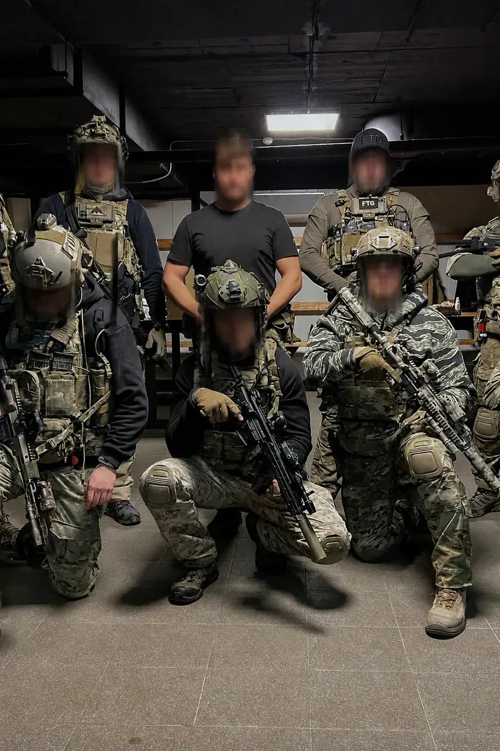 Group of men in tactical gear posing indoors.